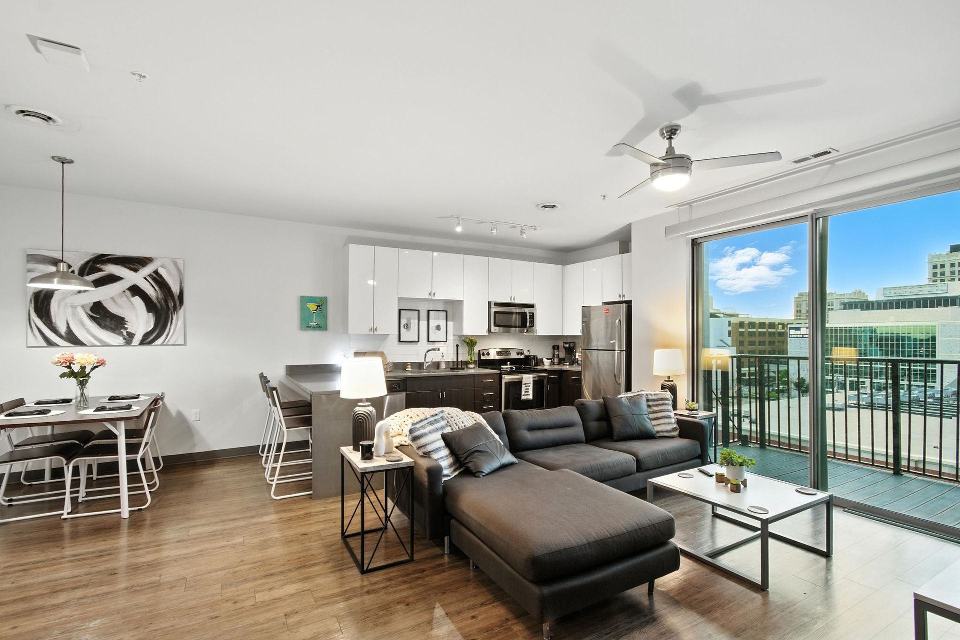 L-shaped couch in open living room and kitchen area of apartment