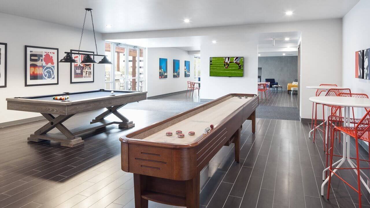game room in apartment complex with pool table and TV