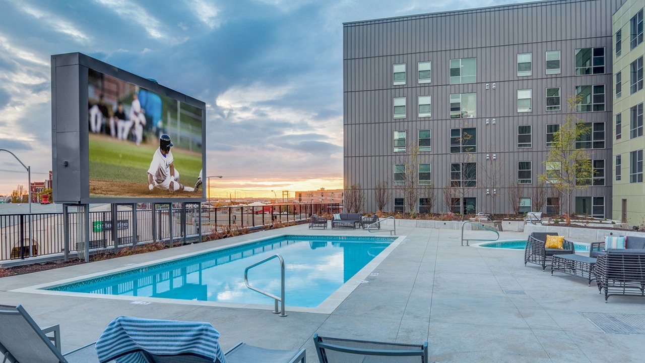 outdoor pool with very large TV screen on one side