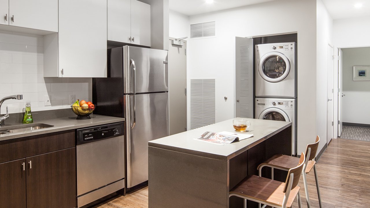 kitchen with stainless steel appliances and stacked washer and dryer