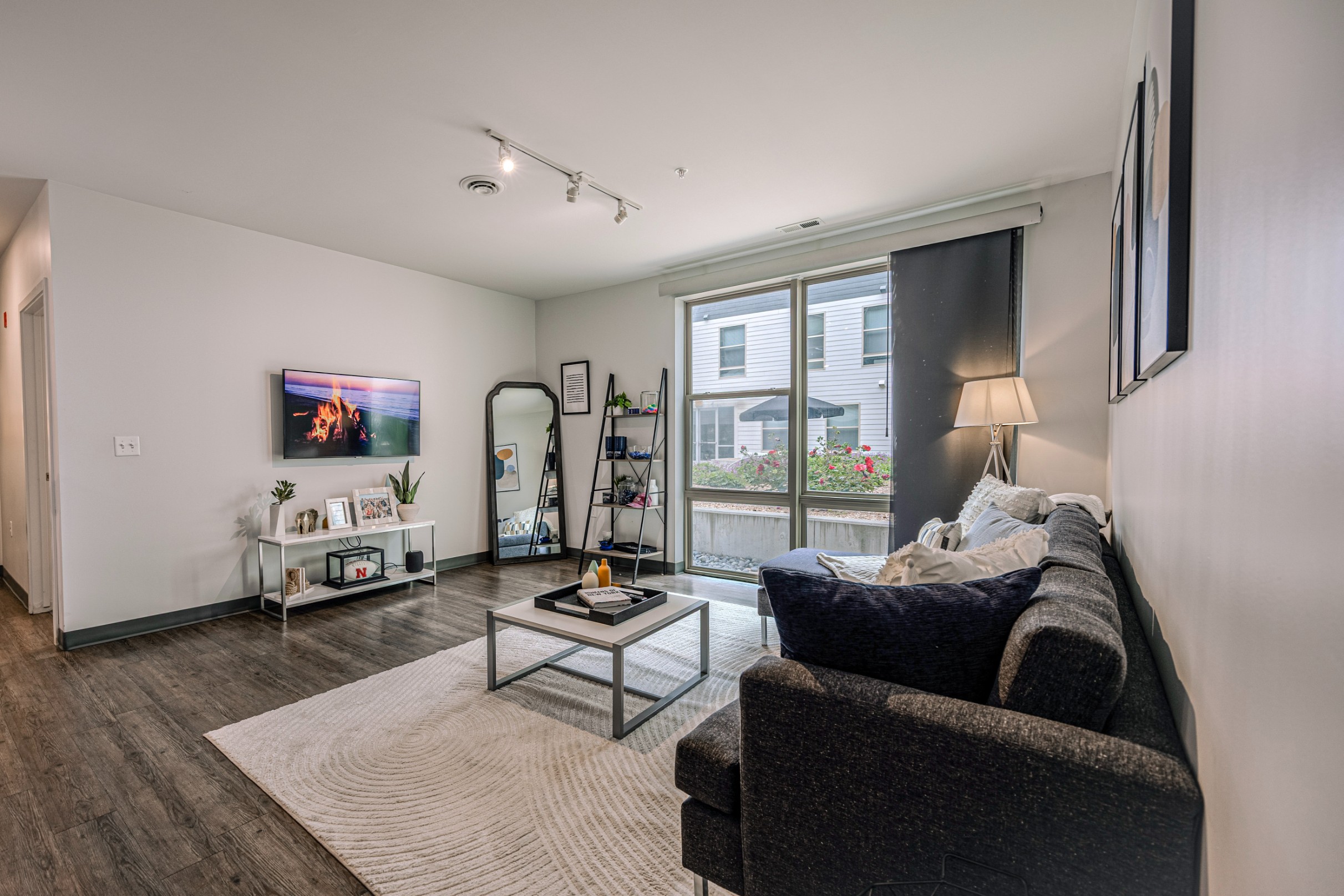Model living room with vinyl plank flooring and large windows